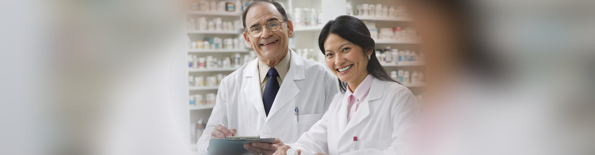 senior pharmacist with his assistant in the drugstore